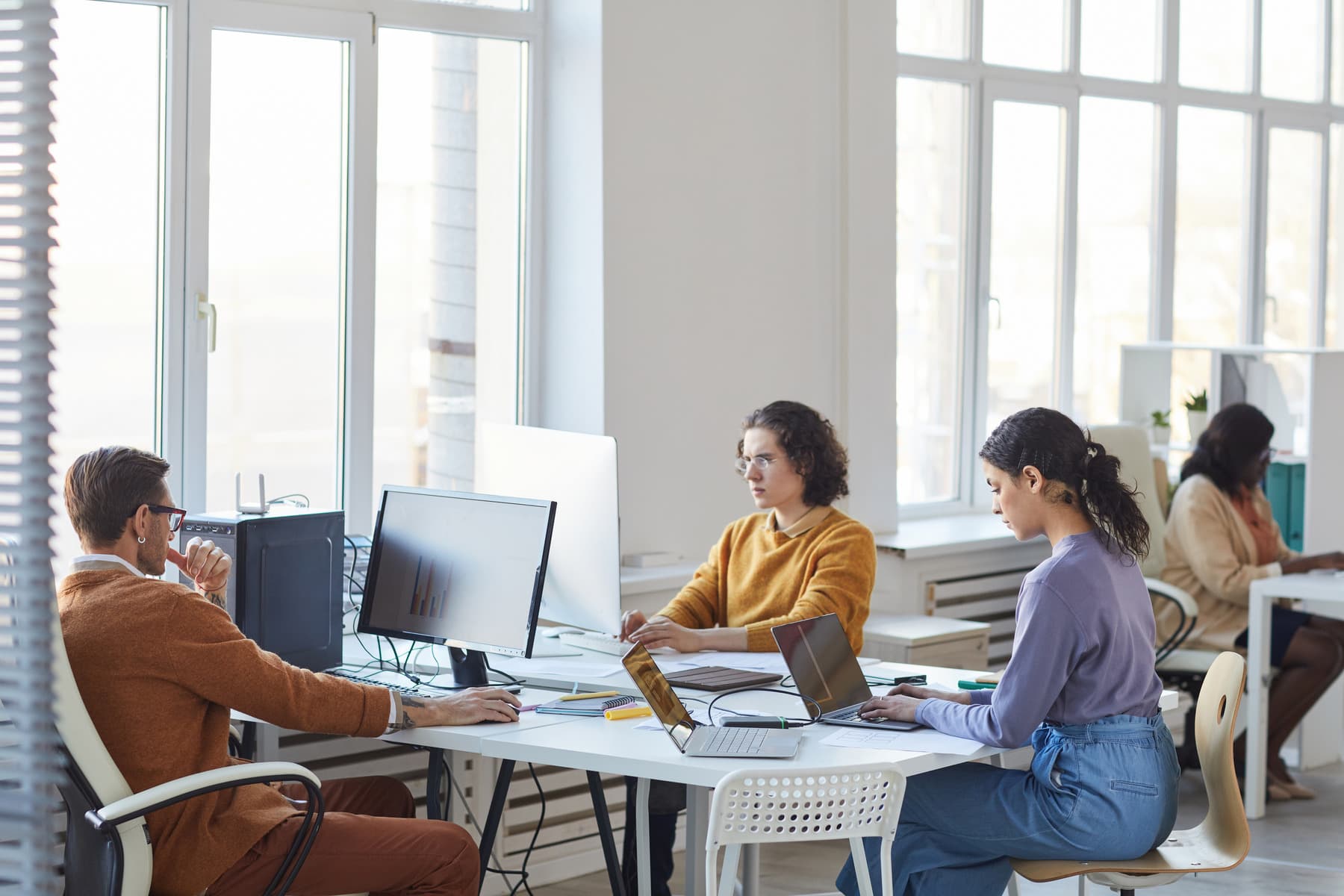 People working at desks in a bright open-plan office